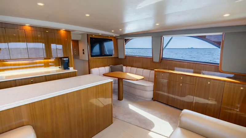 Slide: The Image of Spacious Salon with Ocean Views The salon of the 2007 Viking 45 Convertible offers a luxurious and inviting space with panoramic ocean views. Rich wood cabinetry and plush seating create a warm, elegant atmosphere, while large windows fill the area with natural light. The open layout an - 6394726