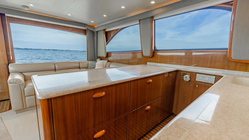 Slide: The Image of Spacious Interior Salon with Ocean View This inviting interior salon of the 2007 Viking 45 Convertible 'Desperado' features a beautifully crafted wood finish and expansive windows offering panoramic ocean views. The space is designed for comfort and style, with plush seating and a polished coun - 6394730