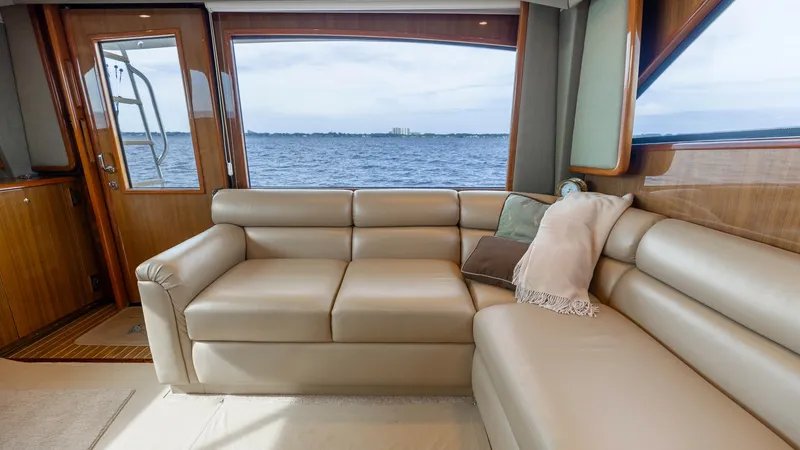 Slide: The Image of Spacious Salon with Panoramic View This inviting salon aboard the 2007 Viking 45 Convertible features a plush L-shaped leather sofa, perfect for relaxation and entertainment. The large windows provide an expansive view of the water, enhancing the open and airy feel of the space. High-quali - 6394733