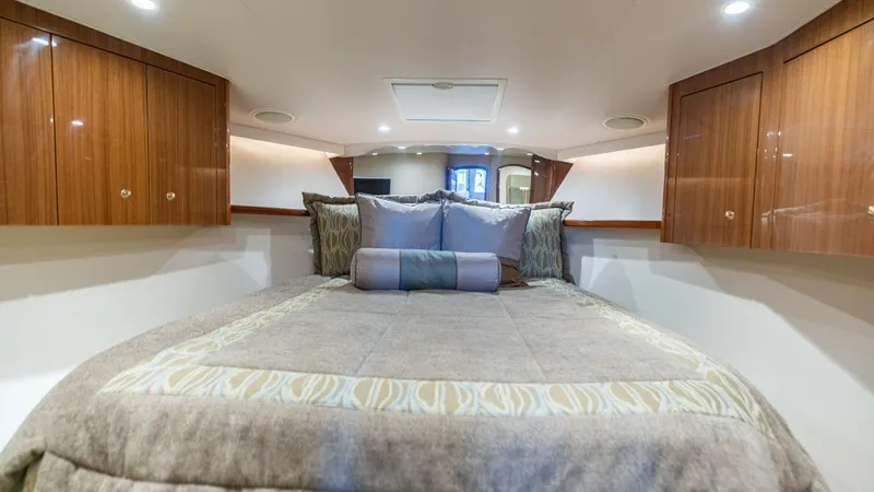 Slide: The Image of Forward Stateroom with Double Berth The forward stateroom of the 2007 Viking 45 Convertible features a plush double berth with elegant bedding, providing a comfortable retreat. Rich wood cabinetry offers ample storage and complements the sophisticated interior. Recessed lighting and soft ac - 6394736