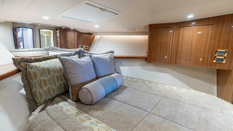 Slide: The Image of Luxurious Forward Stateroom This inviting forward stateroom on the 2007 Viking 45 Convertible features a plush queen-sized berth with elegant bedding and accent pillows. Rich wood cabinetry provides ample storage, complemented by soft ambient lighting that enhances the room's warmth - 6394738