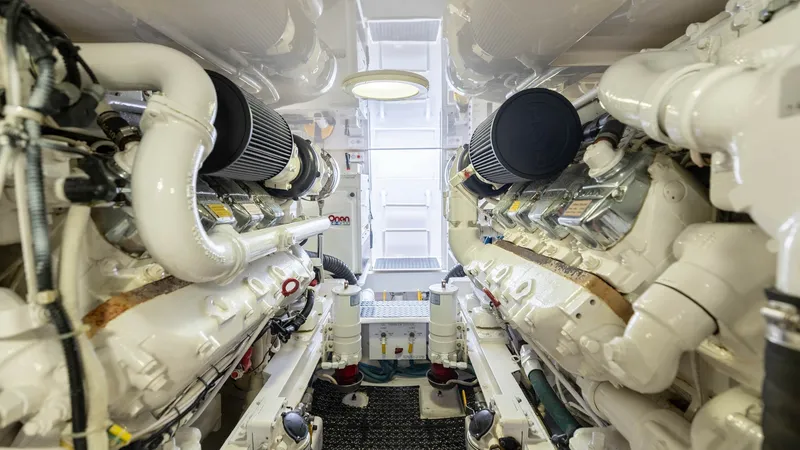 Slide: The Image of Engine Room with Twin Engines The engine room of the 2007 Viking 45 Convertible, 'Desperado,' showcases its powerful twin engines. The space is meticulously organized, with clean, easy-to-access components, ensuring efficient maintenance. Bright overhead lighting and non-slip flooring - 6394750