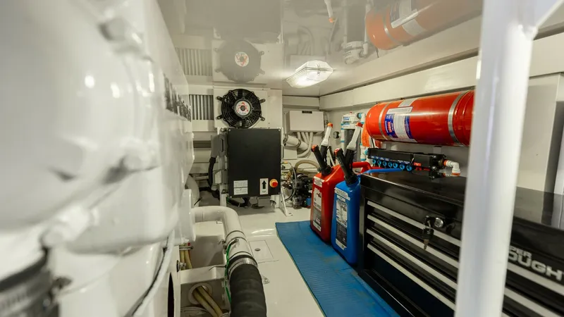Slide: The Image of Engine Room with Tool Storage The engine room of the 2007 Viking 45 Convertible 'Desperado' showcases a well-organized space featuring essential equipment and tool storage. Notable elements include a neatly arranged toolbox, fire extinguisher, and various maintenance supplies. The bri - 6394752