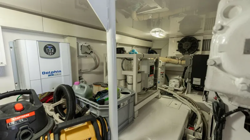 Slide: The Image of Engine Room with Equipment Storage This image showcases the well-organized engine room of the 2007 Viking 45 Convertible, Desperado. Highlighted are essential systems and equipment, including a Dolphin battery charger and various maintenance tools. The space is efficiently arranged, ensuri - 6394753
