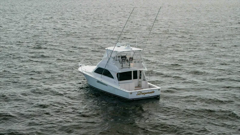 Slide: The Image of Aerial View of Viking 45 Convertible This image captures the Viking 45 Convertible 'Desperado' from an elevated perspective, showcasing its sleek design and spacious aft deck. The flybridge is equipped with a commanding helm station, providing excellent visibility for navigation. The vessel' - 6394755
