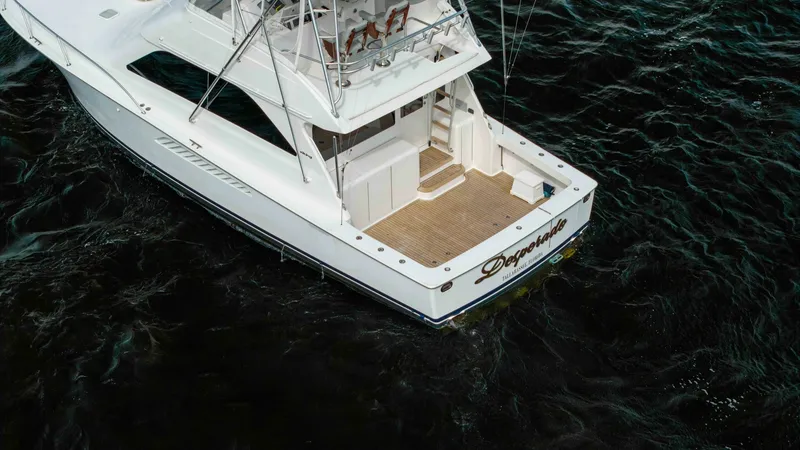 Slide: The Image of Aft Deck and Cockpit Area This image showcases the spacious aft deck and cockpit area of the 2007 Viking 45 Convertible, 'Desperado'. The teak decking provides a classic and elegant touch, perfect for fishing or leisure activities. With easy access to the flybridge and ample seati - 6394760