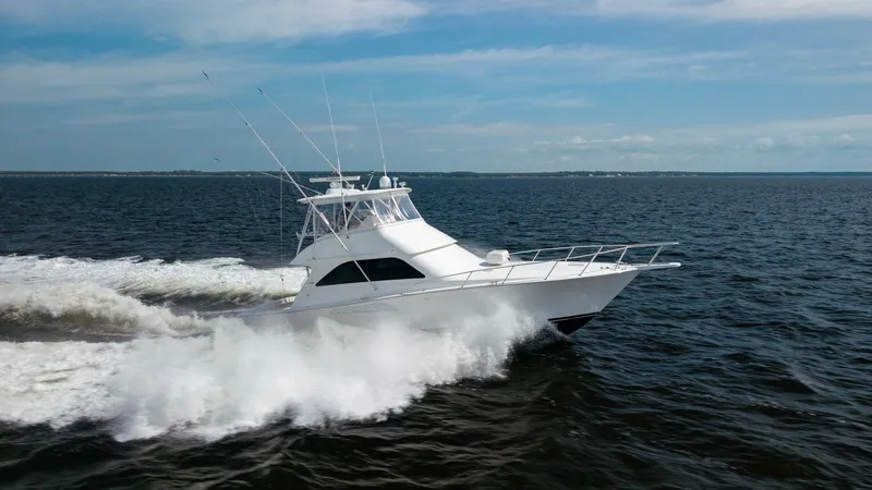 Slide: The Image of Side View of Viking 45 Convertible The 2007 Viking 45 Convertible, Desperado, is captured slicing through the water with precision and power. This side view showcases the sleek, aerodynamic hull design that enhances performance and efficiency. The flybridge is equipped with an array of ant - 6394766