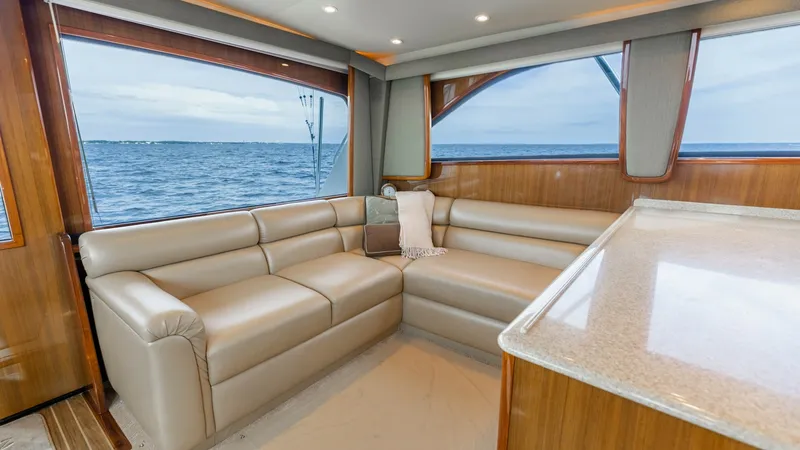 Slide: The Image of Salon with Panoramic Ocean Views Experience comfort and style in the salon of the 2007 Viking 45 Convertible. The plush L-shaped seating offers ample space for relaxation, complemented by high-quality finishes and expansive windows that frame stunning ocean views. The elegant woodwork an - 6394722
