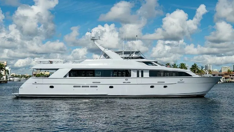 The Image of Port Side View of Magnum Ride This image showcases the sleek port side of the 2003 Hatteras Raised Pilothouse, Magnum Ride. The yacht features a classic white hull with expansive windows that promise panoramic views and abundant natural light inside. The vessel's elegant profile is co - 6388375