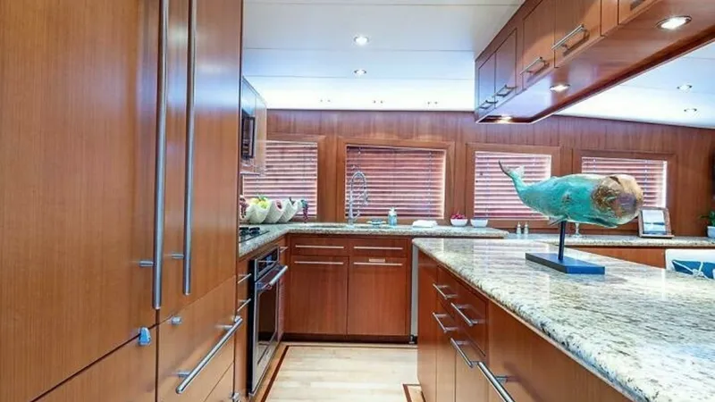 Slide: The Image of Elegant Galley with Granite Counters This sophisticated galley features rich wooden cabinetry and gleaming granite countertops, offering both style and functionality. The ample counter space is complemented by modern appliances seamlessly integrated into the design. Large windows and warm am - 6388386