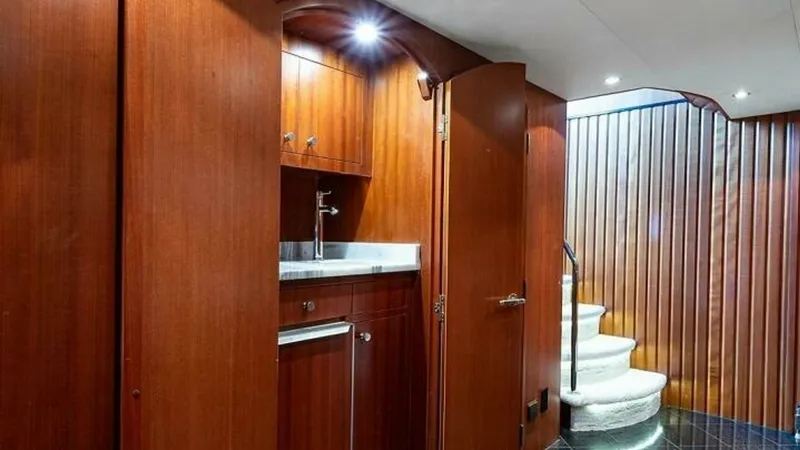 Slide: The Image of Elegant Interior Stairway and Bar Area This image showcases a sophisticated stairway leading to the upper deck, accentuated by rich wooden paneling and sleek finishes. The adjacent bar area features a polished countertop and ambient lighting, adding a touch of luxury and functionality. The des - 6388391