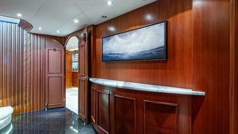 Slide: The Image of Elegant Salon Entrance This inviting salon entrance showcases luxurious wood paneling and a sleek marble-topped console. The artistic wall painting and recessed lighting enhance the sophisticated ambiance, while glossy black flooring adds a touch of modern elegance. The curved - 6388392