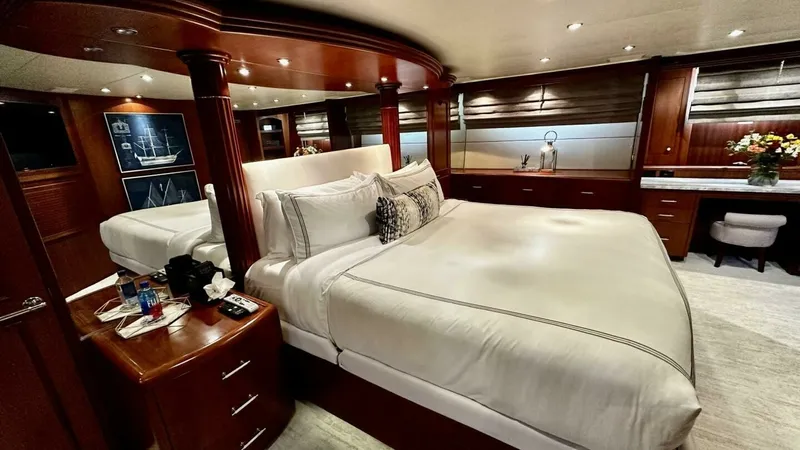 Slide: The Image of Luxurious Master Stateroom This master stateroom aboard the 2003 Hatteras Raised Pilothouse exudes elegance with its rich wood finishes and ambient recessed lighting. The spacious layout features a plush king-sized bed, complemented by ample storage and a refined vanity area. Large - 6388393