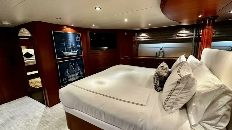Slide: The Image of Luxurious Master Stateroom This inviting master stateroom on the 2003 Hatteras Raised Pilothouse offers a spacious retreat with elegant wood finishes and soft ambient lighting. The plush king-size bed is complemented by tasteful nautical artwork and ample storage, creating a serene - 6388394