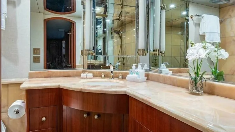 Slide: The Image of Elegant Master Bathroom Vanity This luxurious master bathroom on the 2003 Hatteras Raised Pilothouse features a beautifully crafted vanity with rich wood cabinetry and a polished marble countertop. The mirrored walls enhance the sense of space and brightness, while upscale fixtures and - 6388398