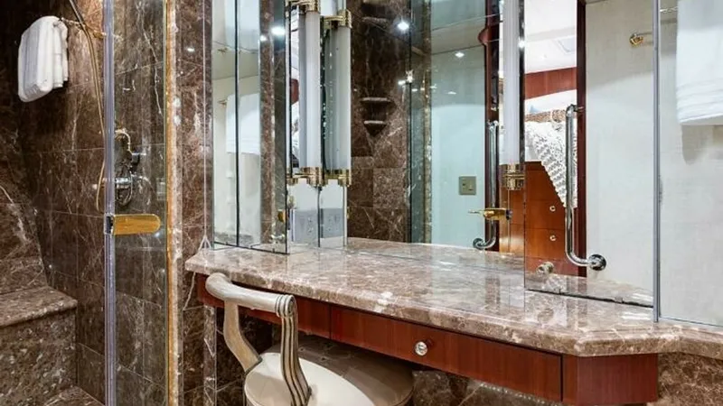 Slide: The Image of Luxurious Marble Vanity Area This elegant vanity area features rich marble surfaces, adding a touch of opulence to the space. The mirrored cabinetry enhances the room's spaciousness, while the plush seating offers comfort and style. Gold accents and sophisticated lighting complete th - 6388404