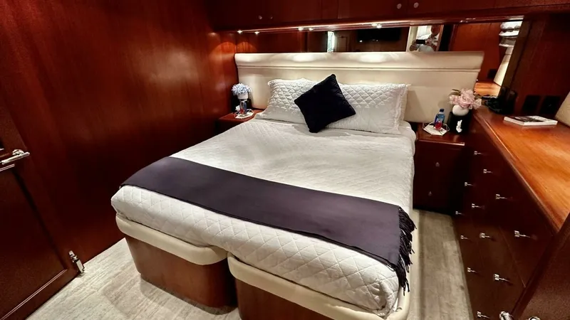 Slide: The Image of Luxurious Guest Stateroom Interior This elegant guest stateroom on the 2003 Hatteras Raised Pilothouse features rich wood paneling and a comfortable double bed adorned with plush bedding. The room is designed for relaxation, offering ample storage with built-in cabinetry, and is beautifull - 6388409