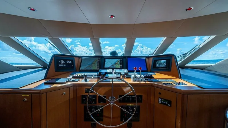 Slide: The Image of Sophisticated Pilothouse Helm Station The helm of the 2003 Hatteras Raised Pilothouse features state-of-the-art navigation displays and controls, offering a commanding view of the ocean through expansive forward windows. The elegant wood finishes complement the modern instrumentation, creatin - 6388414