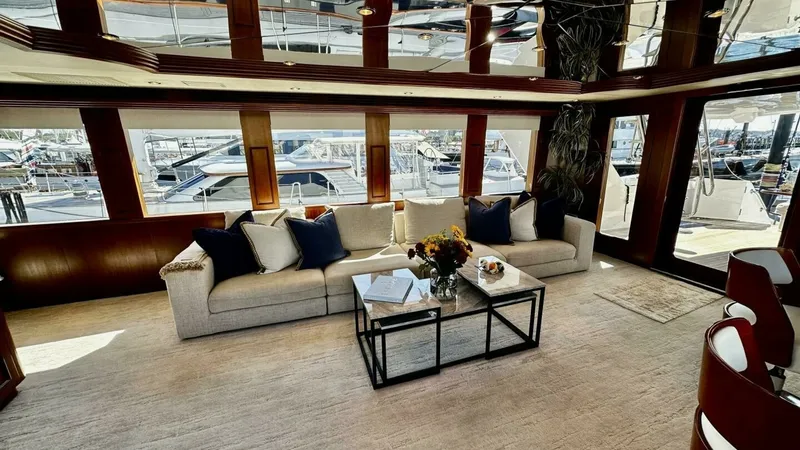 Slide: The Image of Spacious Salon with Large Windows This inviting salon features expansive windows that offer ample natural light and stunning marina views. The plush seating and elegant decor create a welcoming atmosphere for relaxation or entertaining guests. Rich wood finishes and modern accents add a t - 6388379