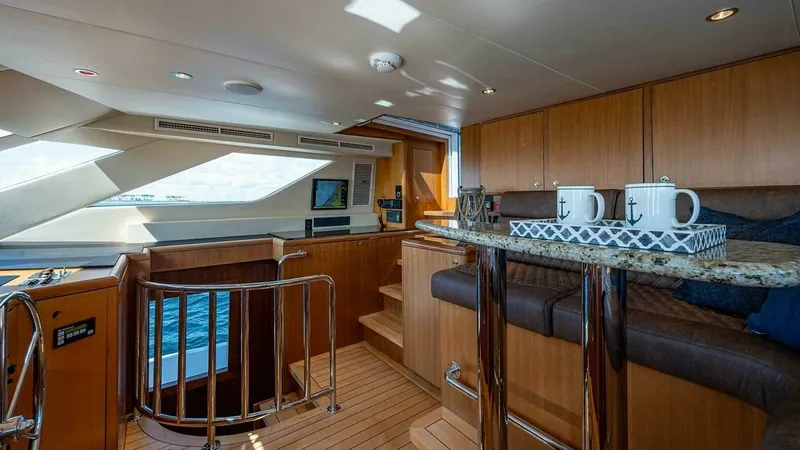 Slide: The Image of Pilothouse with Breakfast Bar This inviting pilothouse features a polished wood interior with a convenient breakfast bar, perfect for casual dining or entertaining. The large windows offer panoramic views, enhancing the sense of space and light throughout the area. Stainless steel rai - 6388416