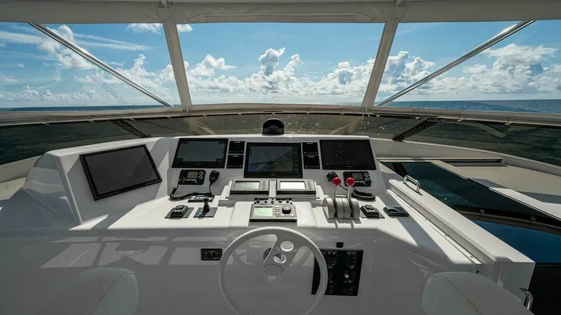 Slide: The Image of Helm Station with Panoramic View The helm station of the 2003 Hatteras Raised Pilothouse offers a commanding view of the ocean, accentuated by expansive windows. Equipped with state-of-the-art navigation systems and ergonomic controls, it ensures a seamless and intuitive piloting experie - 6388419