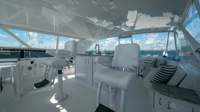 Slide: The Image of Flybridge Helm and Seating Area The flybridge of the 2003 Hatteras Raised Pilothouse boasts a spacious helm with plush captain's chairs and panoramic views. The clean white finish enhances the airy feel, complemented by ample seating and elegant cabinetry. Ideal for navigation and relax - 6388421