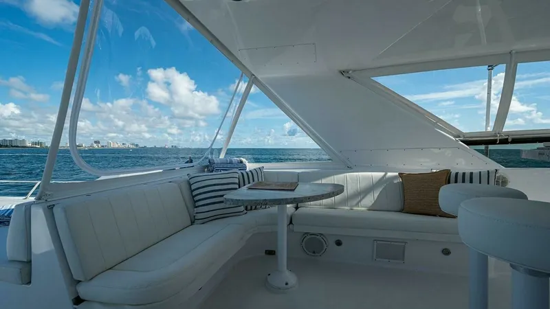 Slide: The Image of Flybridge Seating Area with Ocean View This inviting flybridge features a spacious seating area, perfect for relaxing while taking in panoramic ocean views. The plush white seating is complemented by a sleek table, ideal for entertaining guests or enjoying a meal. The area is sheltered by a pr - 6388422