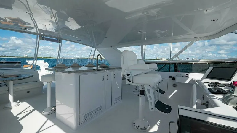 Slide: The Image of Flybridge with Helm Station and Seating The flybridge of the 2003 Hatteras Magnum Ride showcases a spacious helm station with a comfortable captain's chair, surrounded by sleek cabinetry and ample counter space. The area is designed for optimal visibility and functionality, featuring modern nav - 6388425