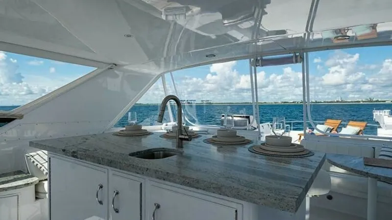 Slide: The Image of Spacious Aft Deck with Wet Bar This inviting aft deck features a sleek granite-topped wet bar, perfect for outdoor entertaining. Surrounded by panoramic ocean views, the area includes comfortable seating and a well-appointed dining space. The Hatteras craftsmanship is evident in the el - 6388427