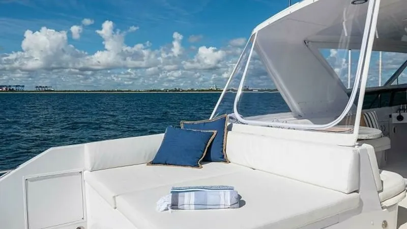 Slide: The Image of Spacious Aft Deck Lounge Area The aft deck of the Hatteras Raised Pilothouse offers a luxurious lounging experience with plush white cushions and nautical-themed pillows. This open-air space is perfect for enjoying panoramic ocean views, enhanced by the protective canopy overhead. The - 6388429