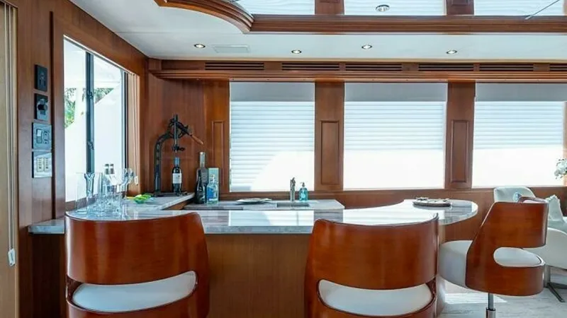 Slide: The Image of Stylish Salon Bar Area The salon bar area of the 2003 Hatteras Raised Pilothouse exudes elegance with its rich wood finishes and sleek design. Featuring comfortable swivel bar stools and a polished countertop, this space is perfect for entertaining guests. Large windows provide - 6388381
