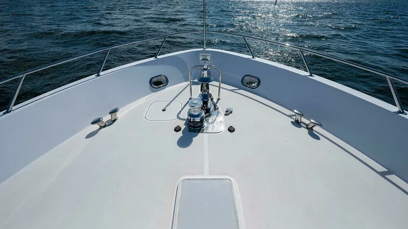 Slide: The Image of Bow Deck with Anchor Equipment The bow of the Magnum Ride, a 2003 Hatteras Raised Pilothouse, features a spacious deck equipped with robust anchor windlass and cleats. The clean, open layout provides ample space for maneuvering and easy access to the anchor system. Stainless steel rail - 6388449