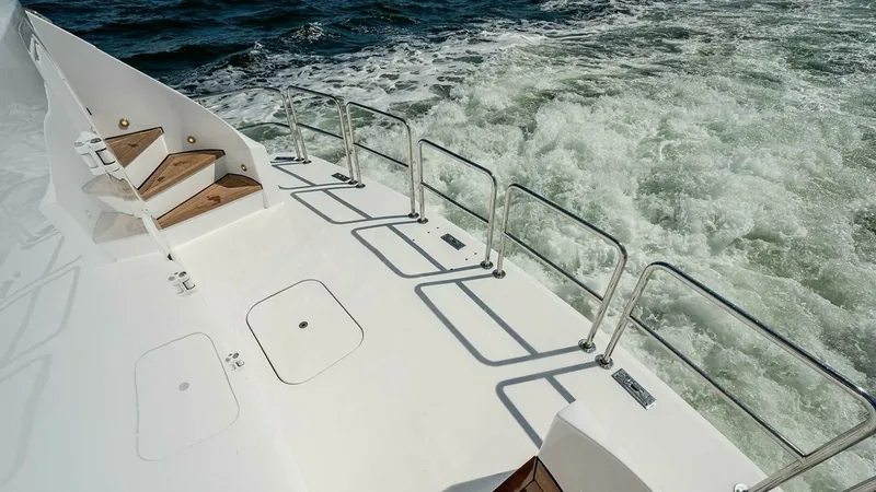 Slide: The Image of Spacious Aft Deck with Safety Rails This image showcases the expansive aft deck of the 2003 Hatteras Raised Pilothouse, Magnum Ride. The area features robust safety rails and convenient access steps, providing both security and ease of movement. The clean, sleek design complements the dynam - 6388450
