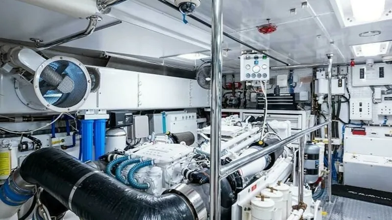 Slide: The Image of Engine Room with Advanced Systems This image showcases the meticulously organized engine room of the Magnum Ride, a 2003 Hatteras Raised Pilothouse. The space is equipped with high-performance machinery and advanced filtration systems, ensuring optimal functionality and reliability. Stain - 6388453