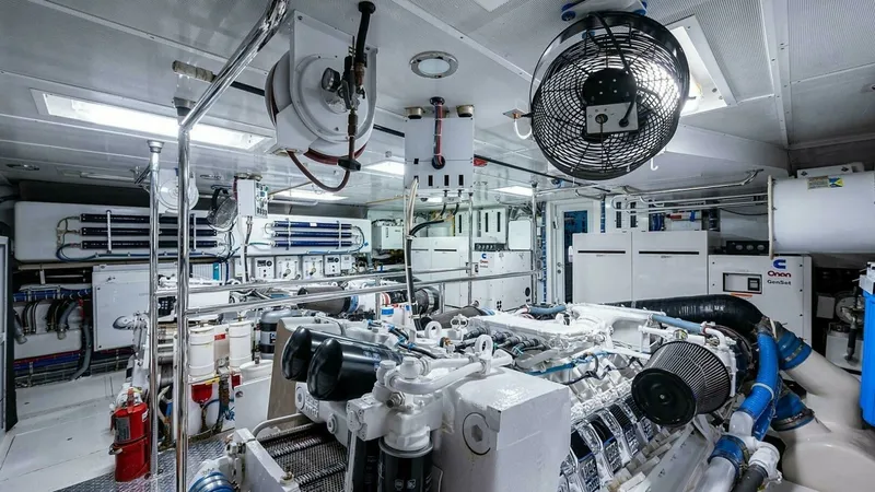 Slide: The Image of Engine Room with Twin Engines The engine room of the 2003 Hatteras Magnum Ride showcases its robust twin engines, essential for powerful and reliable performance. The space is meticulously organized, featuring polished piping and advanced control panels for efficient operation. Overhe - 6388457