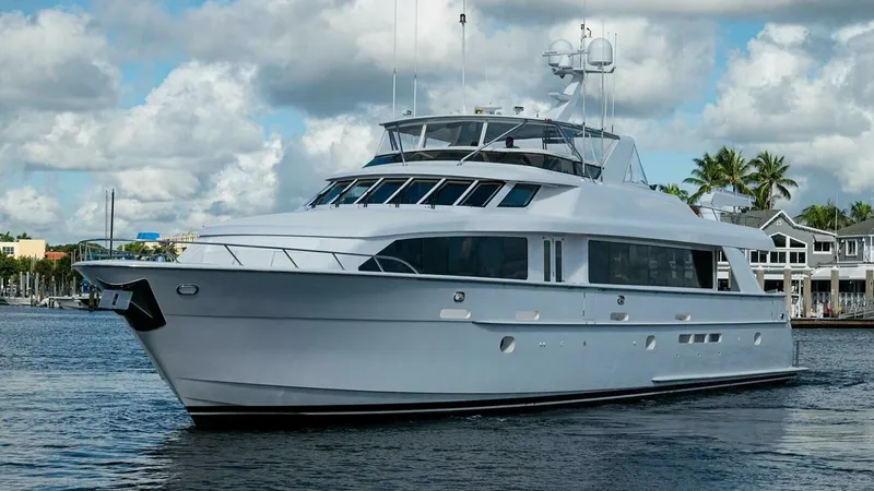 Slide: The Image of Starboard Side Profile in Harbor This image showcases the sleek starboard profile of the 2003 Hatteras Raised Pilothouse yacht, Magnum Ride. The vessel's elegant lines and spacious upper deck are highlighted against a scenic waterfront backdrop. Large windows along the hull provide ample - 6388462