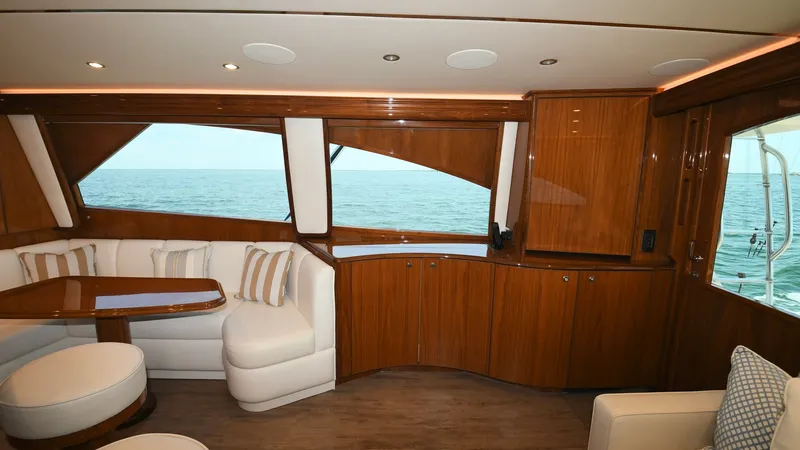 Slide: The Image of Salon with Ocean View The salon of the 2020 Viking 58 Convertible boasts expansive ocean views through large, elegantly framed windows. The interior features luxurious wood finishes and plush seating, creating a warm and inviting atmosphere. The space is designed for comfort a - 6388299