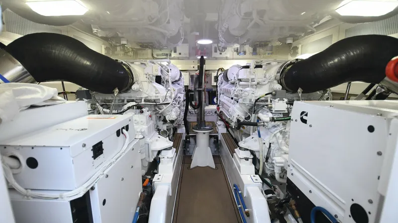 Slide: The Image of Engine Room with Twin Engines The engine room of the 2020 Viking 58 Convertible showcases twin powerful engines, highlighting the yacht's robust performance capabilities. The space is meticulously organized, with high-gloss finishes and ample lighting, ensuring easy maintenance and op - 6388310