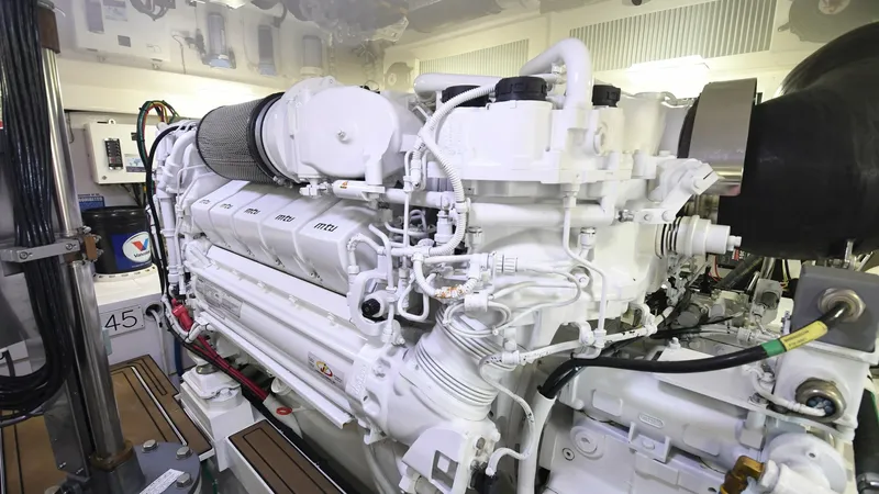 Slide: The Image of Engine Room with Diesel Engine This image showcases the engine room of the 2020 Viking 58 Convertible, featuring a powerful diesel engine. The pristine white finish highlights the meticulous maintenance and advanced engineering. With efficient piping and a robust design, this engine ro - 6388312