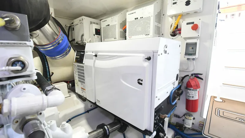 Slide: The Image of Engine Room with Generator The engine room of the 2020 Viking 58 Convertible showcases a well-organized space featuring a Cummins Onan generator. The area is meticulously arranged with advanced control panels and electrical systems for optimal performance and reliability. Bright li - 6388313
