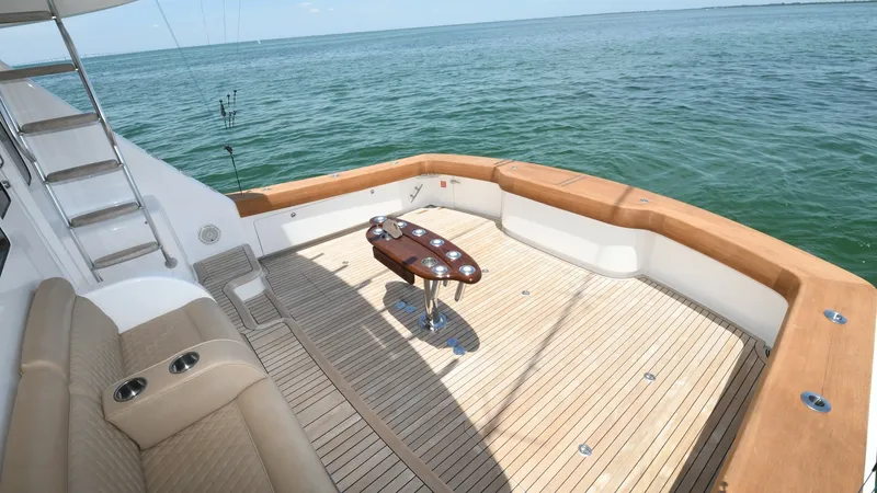 Slide: The Image of Spacious Teak Cockpit with Seating The 2020 Viking 58 Convertible features a generous teak cockpit, perfect for both relaxation and sportfishing. The area is equipped with a stylish fighting chair and plush upholstered seating, offering comfort and functionality. The open space and seamles - 6388315