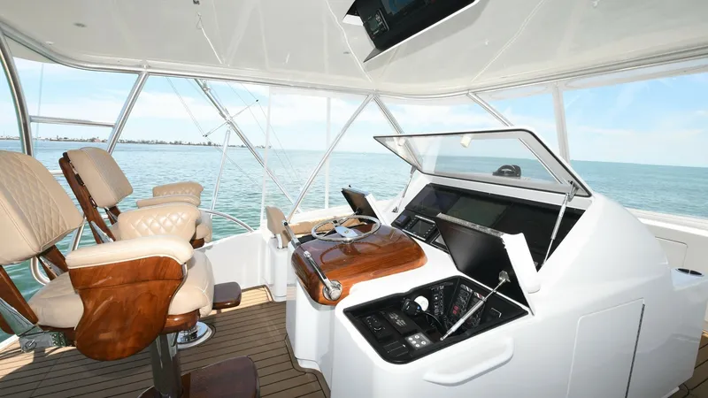 Slide: The Image of Flybridge Helm with Captain's Chairs The 2020 Viking 58 Convertible's flybridge helm is equipped with state-of-the-art navigation technology and dual captain's chairs for optimal comfort and control. The helm features sleek instrumentation and a polished wooden wheel that adds a touch of ele - 6388319