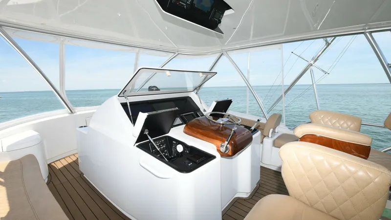 Slide: The Image of Flybridge Helm with Seating Area The flybridge of the 2020 Viking 58 Convertible features a spacious helm equipped with advanced navigation systems and a sleek, polished wooden steering wheel. Surrounding the helm are plush, diamond-stitched leather seats, providing comfort and style for - 6388320