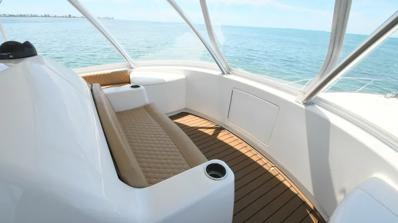 Slide: The Image of Flybridge Seating Area with Ocean View This image showcases the spacious flybridge seating area on the 2020 Viking 58 Convertible. The comfortable, cushioned bench seating offers a luxurious spot to enjoy panoramic views of the ocean. The teak decking adds a touch of elegance, while the built- - 6388321
