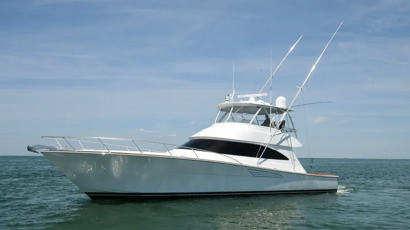 Slide: The Image of Viking 58 Convertible Exterior View This image showcases the sleek exterior of the 2020 Viking 58 Convertible, cutting through the water with its elegant design. The yacht features a spacious flybridge, equipped with advanced navigation equipment and ample seating for comfort. Its robust hu - 6388325