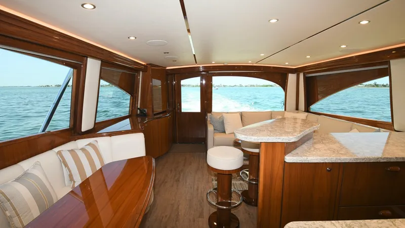 Slide: The Image of Elegant Salon with Ocean Views This spacious salon on the 2020 Viking 58 Convertible boasts a sophisticated blend of comfort and style. Featuring plush seating and a polished wooden table, the area is perfect for socializing and relaxation. The large windows offer stunning panoramic vi - 6388290