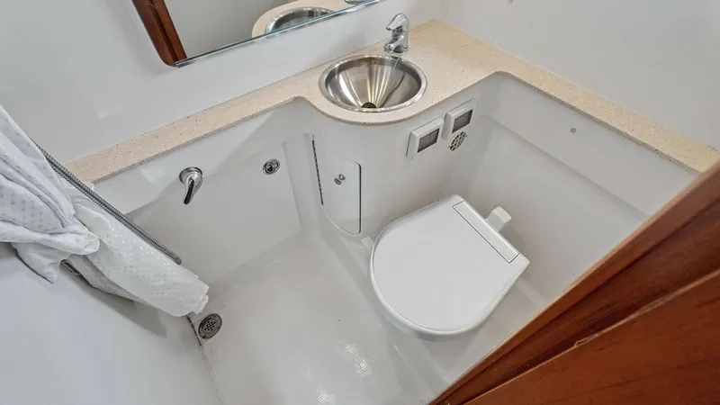 Slide: The Image of Compact Yacht Head with Vanity This well-designed yacht head features a sleek stainless steel sink and a practical countertop with ample space for toiletries. The compact yet efficient layout includes a marine toilet and integrated storage solutions, ensuring convenience and functional - 6394580