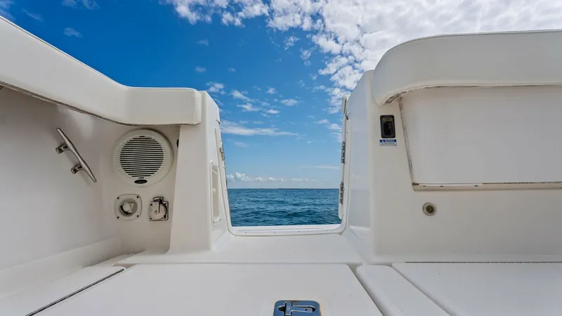 Slide: The Image of Aft Deck Entryway with Ocean View This image showcases the aft deck entryway of the 2007 Tiara Yachts 32 Open. The spacious deck features a clean, white finish, complemented by built-in speakers for an enhanced onboard experience. The open view to the ocean offers an inviting glimpse of t - 6394585