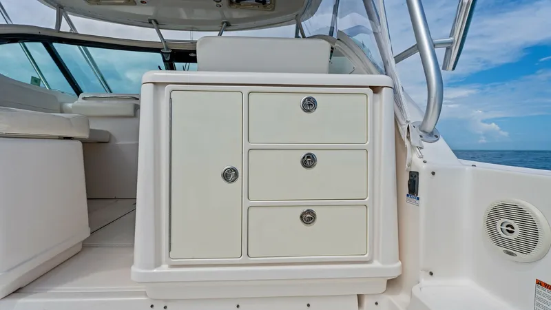 Slide: The Image of Helm Storage Compartment This image showcases the helm storage compartment of the 2007 Tiara 32 Open. The unit features a sleek, white finish with multiple lockable drawers, providing ample space for storing essential items. The surrounding area is designed for comfort and functi - 6394588