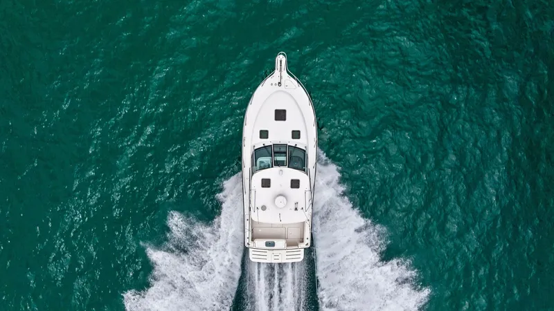 Slide: The Image of Aerial View of Bow on the Water This aerial shot showcases the sleek design of the 2007 Tiara Yachts 32 Open, slicing through the water with precision. The spacious bow features a clean layout with ample deck space, providing excellent visibility and comfort. The vessel's white hull con - 6394571